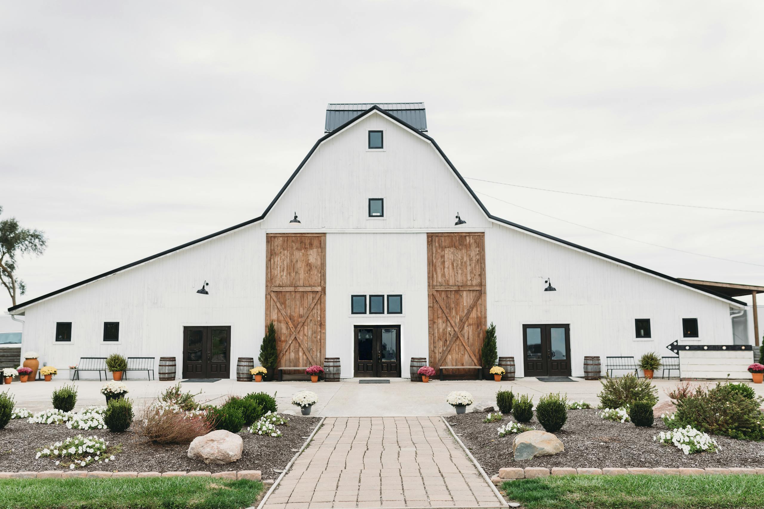 A spacious white barn serving as a venue, showcasing rustic architecture and countryside charm.
